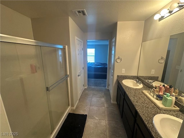 7636 Bandon Cliffs St, North Las Vegas, NV 89084 - full bath with double vanity, a stall shower, tile patterned flooring, and a textured ceiling