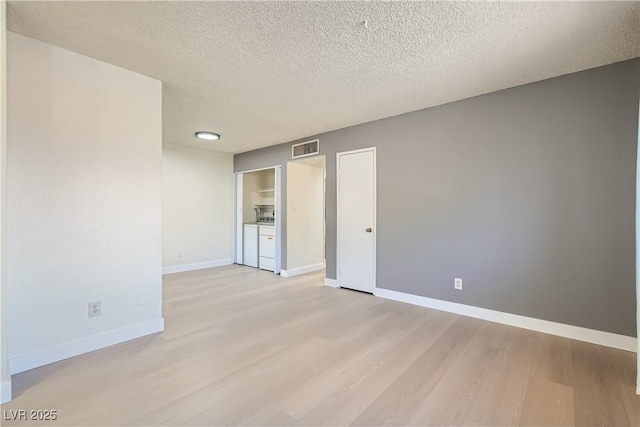 4683 Monterey Cir Unit 4, Las Vegas, NV 89169 - unfurnished bedroom featuring light wood-style flooring, washer and clothes dryer, and a textured ceiling