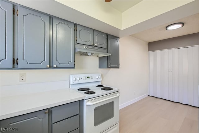 4683 Monterey Cir Unit 4, Las Vegas, NV 89169 - kitchen with white range with electric stovetop, under cabinet range hood, gray cabinetry, light wood-style flooring, and light countertops