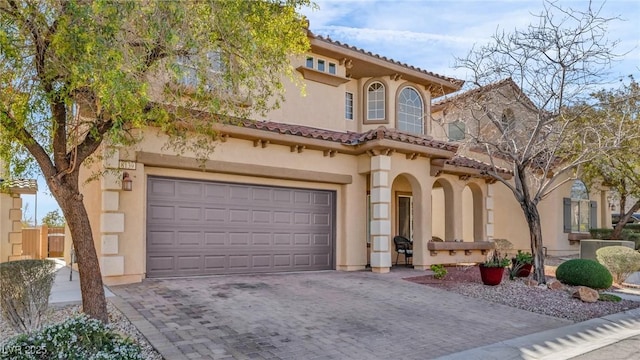 8139 Skytop Ledge Ave, Las Vegas, NV 89178 - mediterranean / spanish house featuring stucco siding, decorative driveway, an attached garage, and a tiled roof
