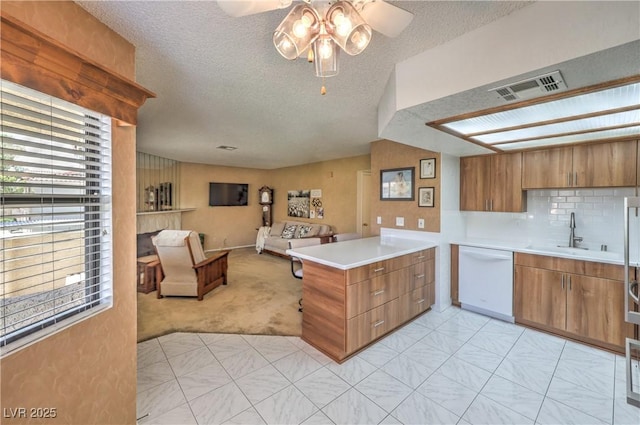 1201 N Buffalo Dr Unit 202, Las Vegas, NV 89128 - kitchen featuring dishwasher, open floor plan, plenty of natural light, brown cabinets, and a textured ceiling