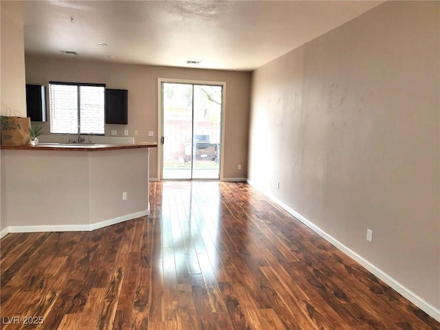10719 Tottenham Ave, Las Vegas, NV 89135 - unfurnished living room featuring dark wood-style floors and a sink