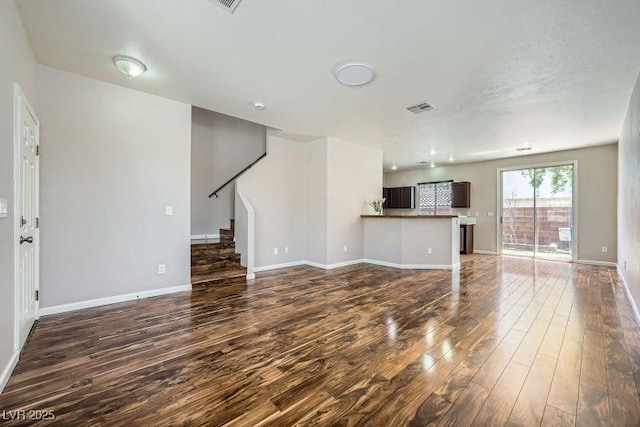 10719 Tottenham Ave, Las Vegas, NV 89135 - unfurnished living room with dark wood-type flooring and stairs