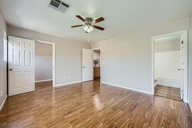 10719 Tottenham Ave, Las Vegas, NV 89135 - unfurnished bedroom featuring wood finished floors, a spacious closet, a closet, ensuite bathroom, and ceiling fan