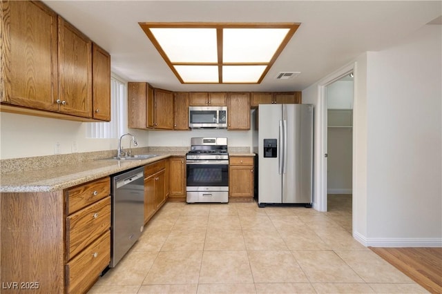 3972 Tirana Way, Las Vegas, NV 89103 - kitchen featuring stainless steel appliances, brown cabinets, and light tile patterned floors
