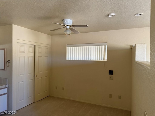3090 N Woodchips Rd, Pahrump, NV 89060 - unfurnished bedroom with light carpet, a closet, a textured ceiling, and a ceiling fan