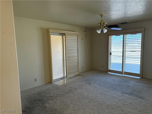 3090 N Woodchips Rd, Pahrump, NV 89060 - carpeted empty room with a ceiling fan, a textured ceiling, and tile patterned flooring