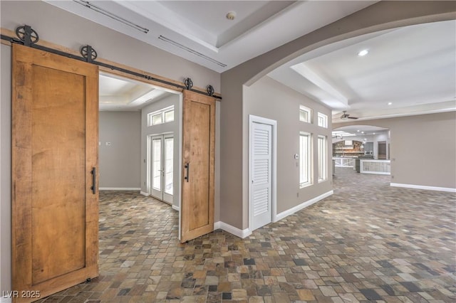 2017 Slow Wind St, Las Vegas, NV 89134 - foyer featuring a tray ceiling, a barn door, ceiling fan, arched walkways, and recessed lighting