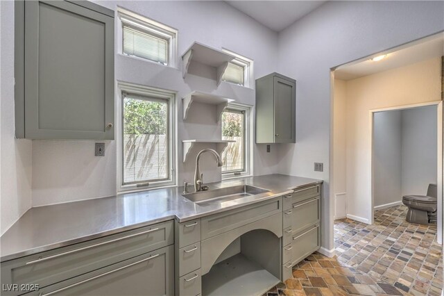 2017 Slow Wind St, Las Vegas, NV 89134 - kitchen with stainless steel countertops, open shelves, gray cabinetry, and stone finish floors