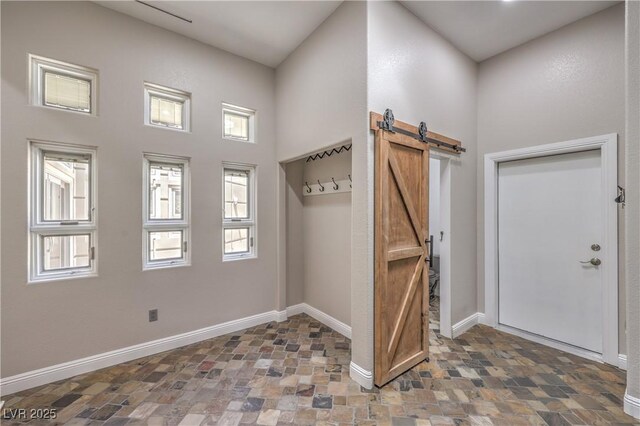 2017 Slow Wind St, Las Vegas, NV 89134 - foyer entrance with stone finish flooring, a barn door, and a towering ceiling