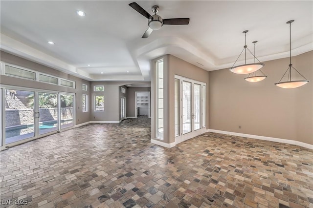 2017 Slow Wind St, Las Vegas, NV 89134 - unfurnished living room with a ceiling fan, a tray ceiling, recessed lighting, and stone finish flooring