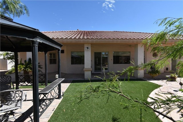7250 Birkland Ct, Las Vegas, NV 89117 - rear view of house featuring a tile roof, stucco siding, a lawn, and ceiling fan