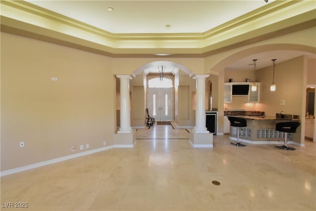 7250 Birkland Ct, Las Vegas, NV 89117 - foyer with decorative columns, a tray ceiling, arched walkways, and light tile patterned floors