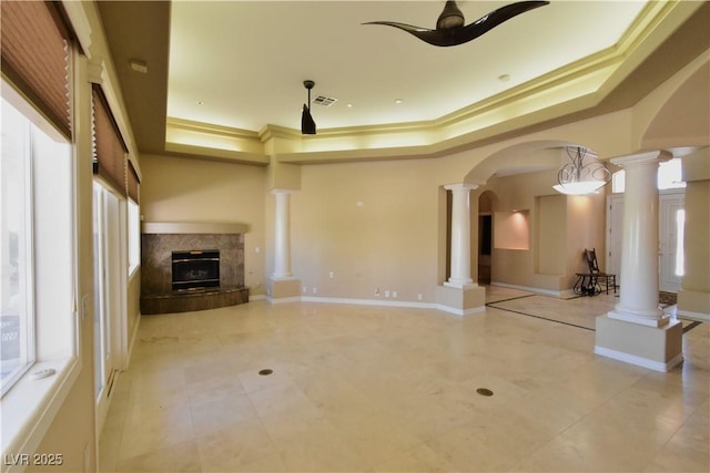 7250 Birkland Ct, Las Vegas, NV 89117 - unfurnished living room featuring decorative columns, a raised ceiling, a premium fireplace, ceiling fan, and ornamental molding