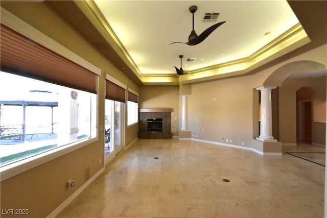 7250 Birkland Ct, Las Vegas, NV 89117 - unfurnished living room with a tray ceiling, a ceiling fan, decorative columns, arched walkways, and light tile patterned floors