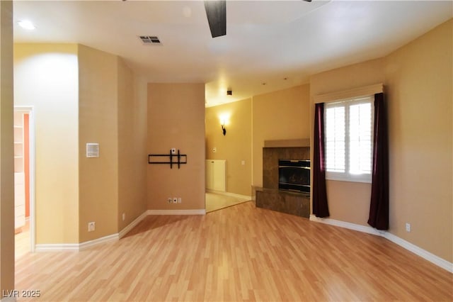 7250 Birkland Ct, Las Vegas, NV 89117 - unfurnished living room featuring light wood-style flooring, a ceiling fan, and a tile fireplace