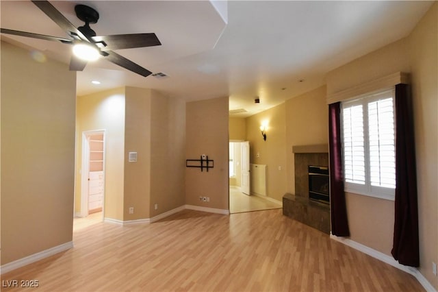 7250 Birkland Ct, Las Vegas, NV 89117 - unfurnished living room featuring light wood-style floors, a ceiling fan, a glass covered fireplace, and recessed lighting