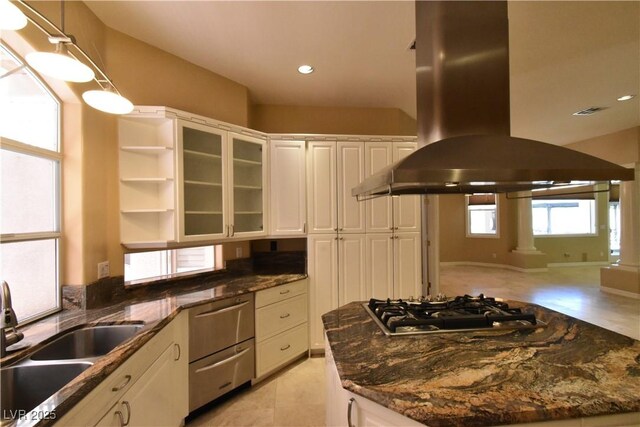 7250 Birkland Ct, Las Vegas, NV 89117 - kitchen featuring island exhaust hood, stainless steel gas stovetop, white cabinets, dishwashing machine, and glass insert cabinets