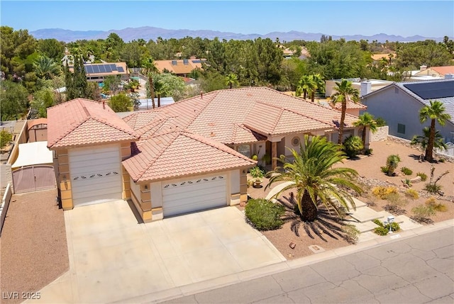 7250 Birkland Ct, Las Vegas, NV 89117 - view of front facade with a tiled roof, a garage, a mountain view, and a gate
