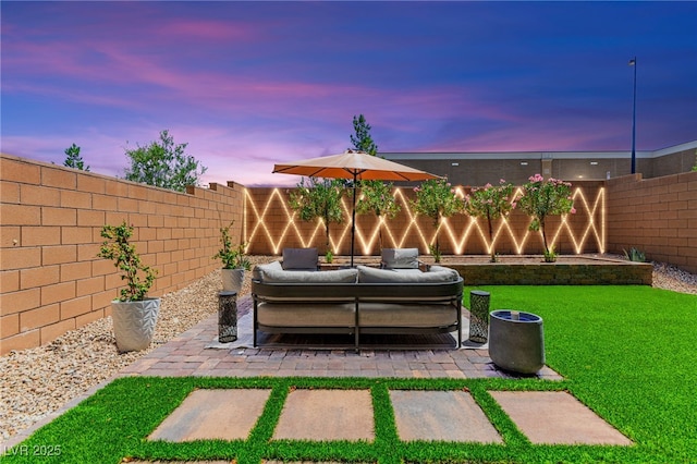 9743 Mojave Mountain St, Las Vegas, NV 89166 - yard at dusk featuring a fenced backyard, a patio area, and an outdoor living space