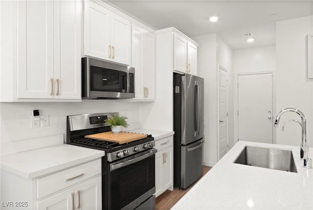9743 Mojave Mountain St, Las Vegas, NV 89166 - kitchen featuring appliances with stainless steel finishes, wood finished floors, light countertops, white cabinetry, and recessed lighting