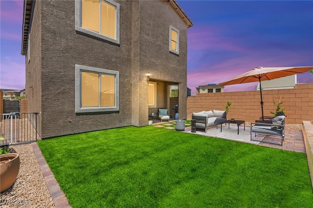 9743 Mojave Mountain St, Las Vegas, NV 89166 - back of property at dusk featuring stucco siding, an outdoor hangout area, a patio area, and a fenced backyard