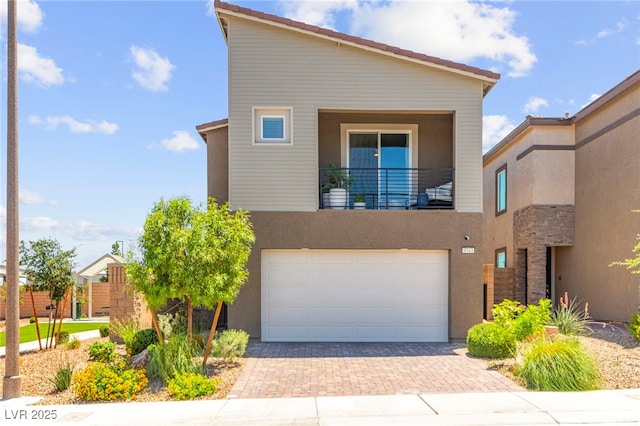 9743 Mojave Mountain St, Las Vegas, NV 89166 - view of front of property featuring a balcony, a garage, decorative driveway, and stucco siding