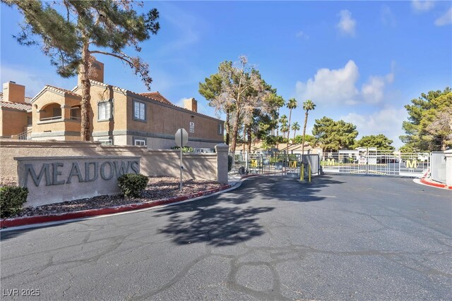 220 Mission Catalina Ln Unit 208, Las Vegas, NV 89107 - view of asphalt road featuring a gate, a gated entry, and curbs