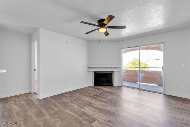 220 Mission Catalina Ln Unit 208, Las Vegas, NV 89107 - unfurnished living room featuring wood finished floors, a ceiling fan, and a fireplace