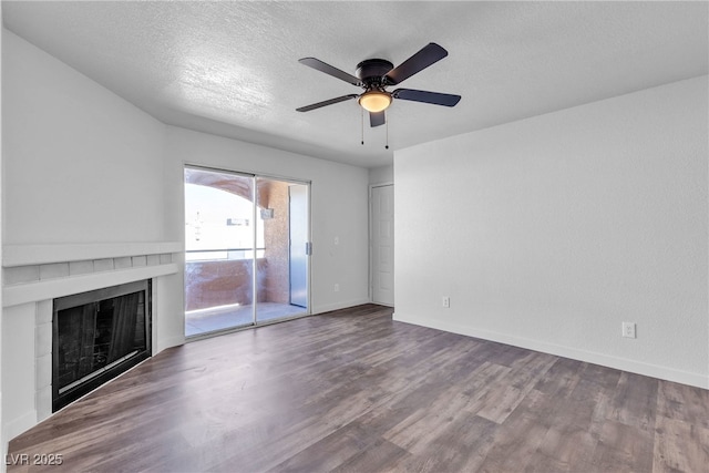 220 Mission Catalina Ln Unit 208, Las Vegas, NV 89107 - unfurnished living room featuring a fireplace, wood finished floors, a ceiling fan, and a textured ceiling