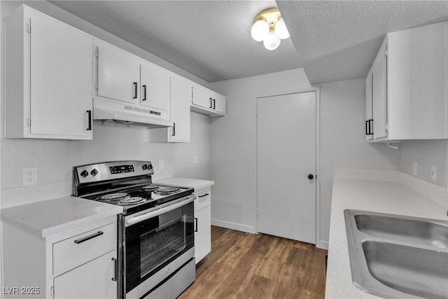 220 Mission Catalina Ln Unit 208, Las Vegas, NV 89107 - kitchen with stainless steel range with electric cooktop, under cabinet range hood, light countertops, dark wood finished floors, and white cabinetry