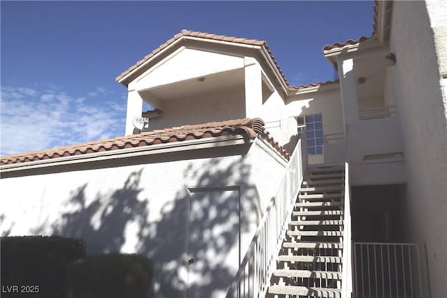 75 N Valle Verde Dr Unit 225, Henderson, NV 89074 - view of front facade featuring a tiled roof, stucco siding, and stairs