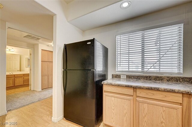 6160 Rumrill St Unit 202, Las Vegas, NV 89113 - kitchen featuring freestanding refrigerator, light wood-style floors, light brown cabinetry, and dark countertops