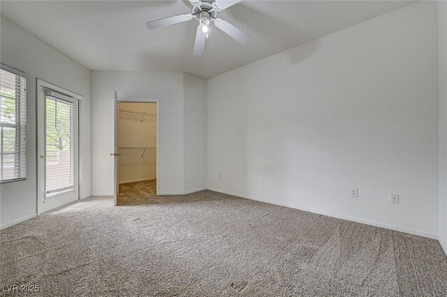6160 Rumrill St Unit 202, Las Vegas, NV 89113 - unfurnished bedroom featuring carpet, access to exterior, a walk in closet, and a ceiling fan