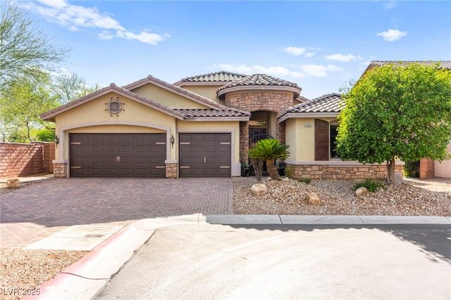 9685 Stonily Ln, Las Vegas, NV 89178 - mediterranean / spanish-style house with stone siding, stucco siding, decorative driveway, a garage, and a tile roof