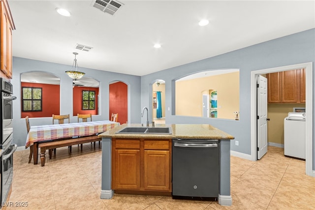 9685 Stonily Ln, Las Vegas, NV 89178 - kitchen featuring stainless steel appliances, washer / dryer, arched walkways, light countertops, and decorative light fixtures