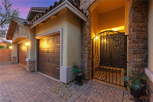 9685 Stonily Ln, Las Vegas, NV 89178 - doorway to property with stucco siding, an attached garage, decorative driveway, and stone siding