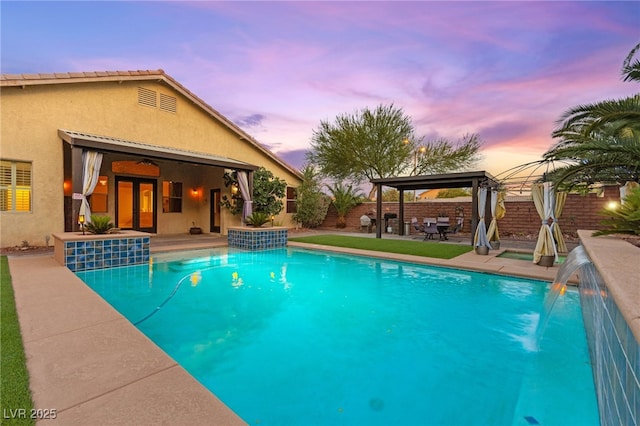 9685 Stonily Ln, Las Vegas, NV 89178 - pool at dusk featuring a gazebo, a fenced backyard, and a patio