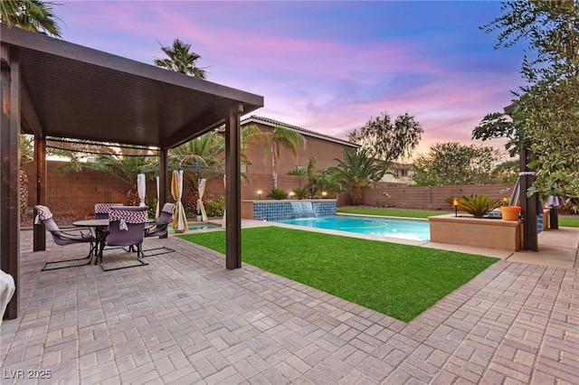 9685 Stonily Ln, Las Vegas, NV 89178 - pool at dusk with a patio, a fenced backyard, and outdoor dining area