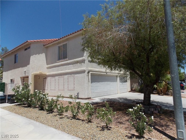 1018 Sun Poppy Ave, Las Vegas, NV 89123 - view of side of home featuring stucco siding, a garage, a tiled roof, and concrete driveway