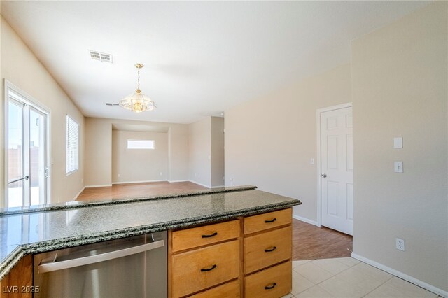 5282 Monterey Park Cir, Las Vegas, NV 89146 - kitchen featuring dishwasher, pendant lighting, dark stone counters, brown cabinets, and light tile patterned floors