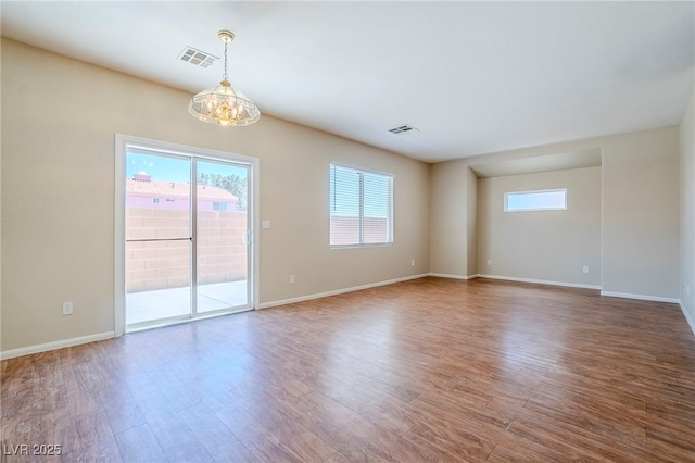5282 Monterey Park Cir, Las Vegas, NV 89146 - unfurnished room with a chandelier, plenty of natural light, and wood finished floors