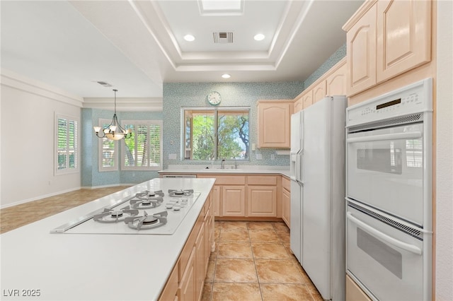 10548 Findlay Ave, Las Vegas, NV 89134 - kitchen featuring light brown cabinets, white appliances, light countertops, a chandelier, and a tray ceiling