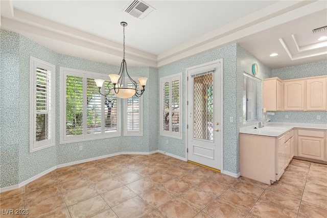 10548 Findlay Ave, Las Vegas, NV 89134 - kitchen with light brown cabinetry, a chandelier, light countertops, a tray ceiling, and wallpapered walls