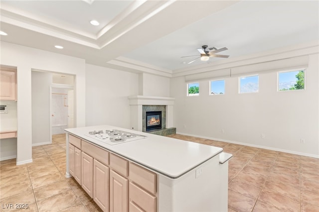 10548 Findlay Ave, Las Vegas, NV 89134 - kitchen featuring white gas cooktop, a raised ceiling, a ceiling fan, light brown cabinets, and a kitchen island