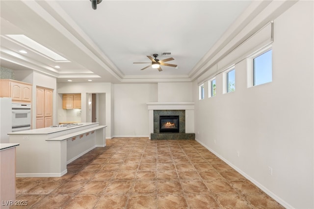 10548 Findlay Ave, Las Vegas, NV 89134 - unfurnished living room with a tray ceiling, a ceiling fan, a fireplace, recessed lighting, and ornamental molding