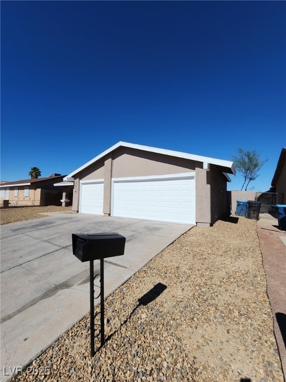 3318 Covey Ln, Las Vegas, NV 89115 - view of side of home featuring stucco siding and concrete driveway