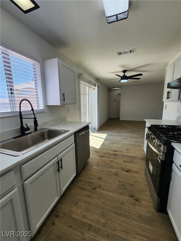 3318 Covey Ln, Las Vegas, NV 89115 - kitchen featuring stainless steel appliances, ceiling fan, a textured ceiling, dark wood-type flooring, and light countertops