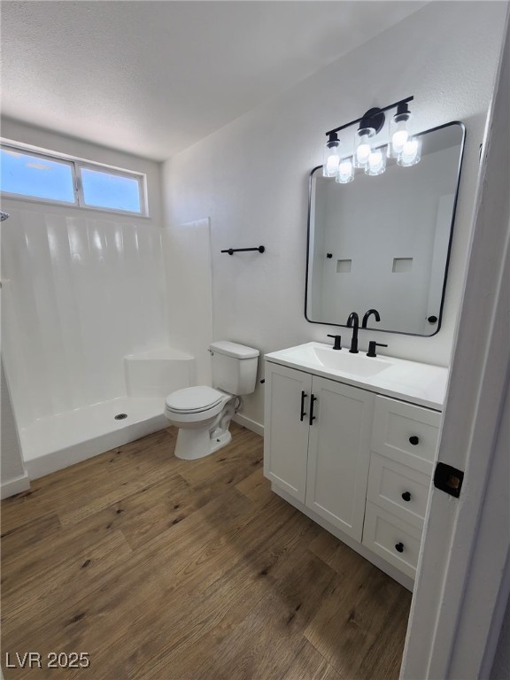 3318 Covey Ln, Las Vegas, NV 89115 - bathroom featuring vanity, a shower, and wood finished floors