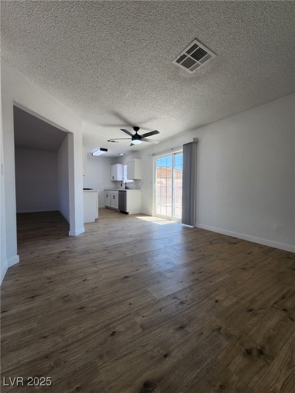 3318 Covey Ln, Las Vegas, NV 89115 - unfurnished living room with ceiling fan, dark wood-type flooring, and a textured ceiling